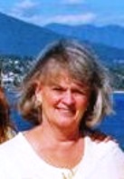 Smiling woman by seaside with mountains