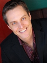Smiling man in black blazer headshot