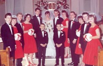 Bridal party in red dresses and tuxedos
